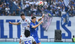 Striker Persib Bandung duel udara berebut bola dengan pemain bertahan lawan demi mengunci gelar juara Super League.