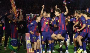 Pemain FC Barcelona merayakan gelar juara LaLiga 2025/2026 setelah mengalahkan Real Madrid 2-0, tampak Lewandowski dan rekan setim mengangkat trofi di lapangan.