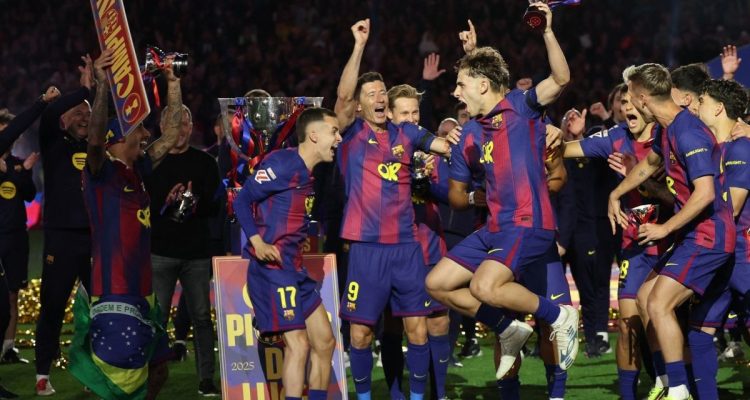 Pemain FC Barcelona merayakan gelar juara LaLiga 2025/2026 setelah mengalahkan Real Madrid 2-0, tampak Lewandowski dan rekan setim mengangkat trofi di lapangan.