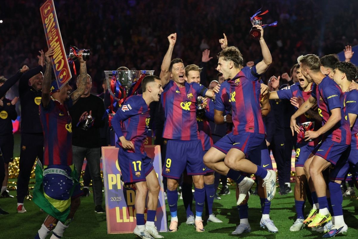 Pemain FC Barcelona merayakan gelar juara LaLiga 2025/2026 setelah mengalahkan Real Madrid 2-0, tampak Lewandowski dan rekan setim mengangkat trofi di lapangan.