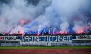 Ribuan Bobotoh Persib memadati tribun stadion dengan suar (flare) dan spanduk raksasa bertuliskan Refuse To Lose saat sesi latihan jelang laga melawan Persija.