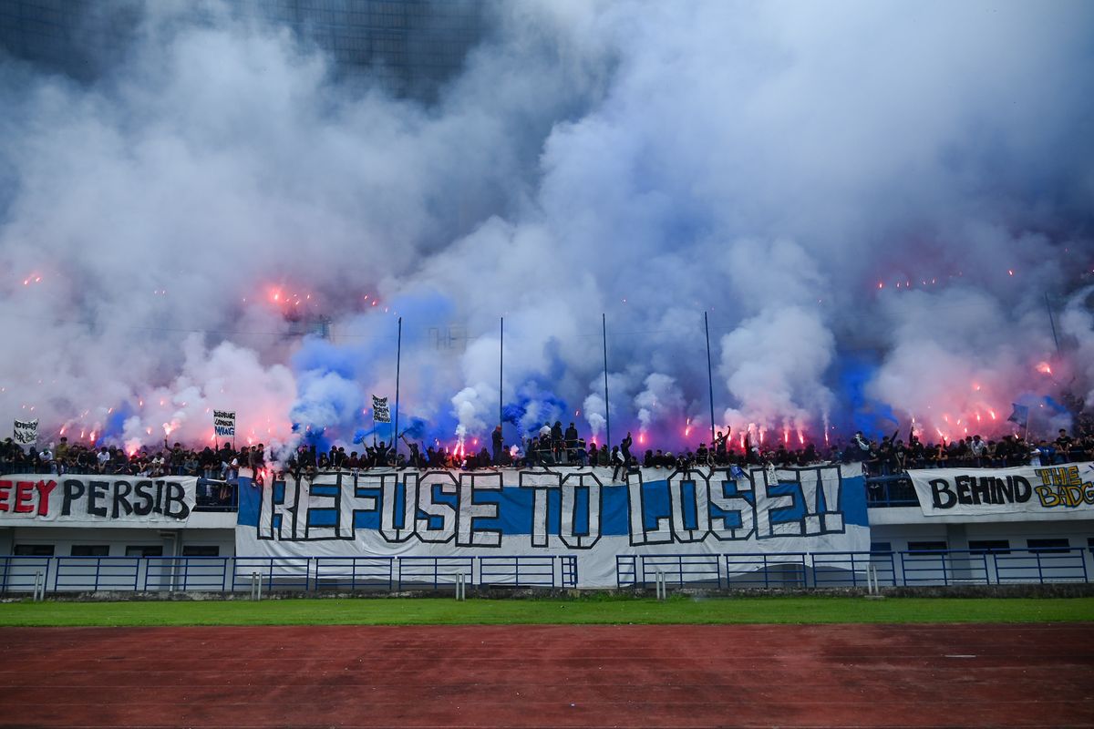 Ribuan Bobotoh Persib memadati tribun stadion dengan suar (flare) dan spanduk raksasa bertuliskan Refuse To Lose saat sesi latihan jelang laga melawan Persija.