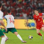 Jay Idzes saat mengontrol bola dalam pertandingan Timnas Indonesia menggunakan jersey merah bernomor punggung 3.