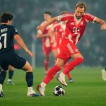 Harry Kane dari Bayern München sedang mendribel bola melewati pemain PSG João Neves dalam pertandingan Liga Champions di Allianz Arena.