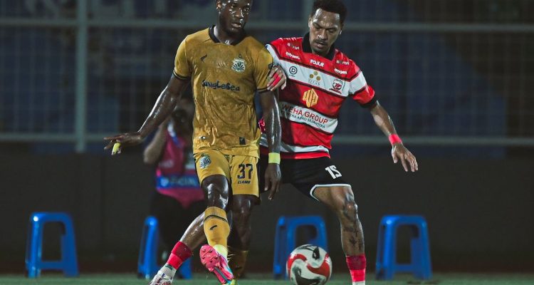 Duel perebutan bola antara pemain Bhayangkara FC dan Madura United dalam pertandingan sengit Liga 1.