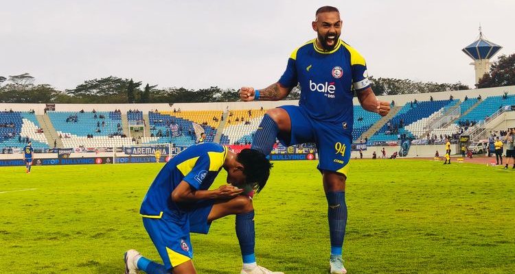 Striker Arema FC melakukan selebrasi ikonik bersama rekan setimnya di tengah lapangan hijau setelah berhasil membobol gawang lawan.