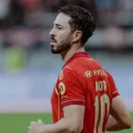 Salah satu kandidat pemain terbaik pekan 30 BRI Super League sedang beraksi di lapangan dengan jersey merah.