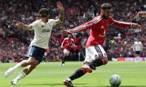 Kapten Manchester United Bruno Fernandes sedang menggiring bola melewati kawalan pemain Nottingham Forest dalam pertandingan Liga Inggris di Old Trafford.