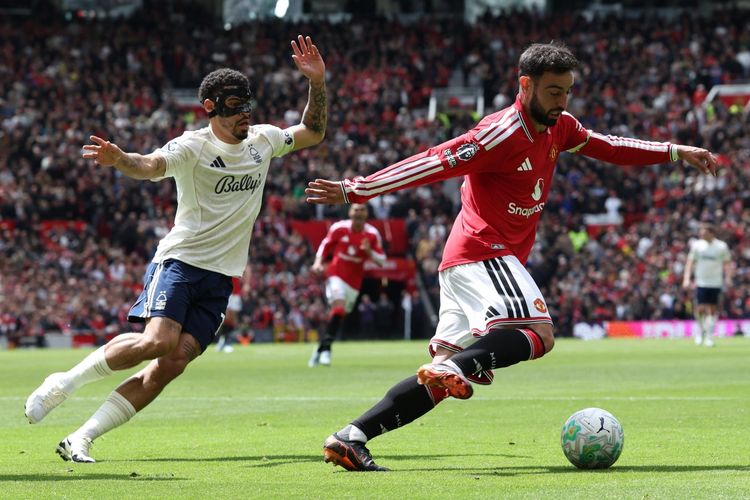 Kapten Manchester United Bruno Fernandes sedang menggiring bola melewati kawalan pemain Nottingham Forest dalam pertandingan Liga Inggris di Old Trafford.