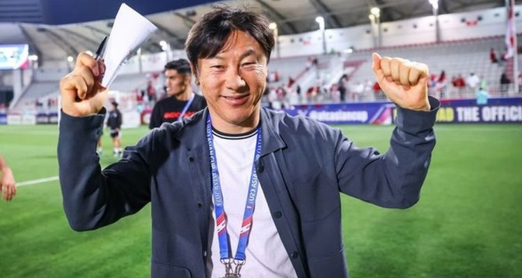 shin-tae-yong-bursa-calon-pelatih-persija.webp Pelatih Shin Tae-yong tersenyum ramah sambil mengepalkan tangan di area stadion sepak bola. Persija Jakarta
