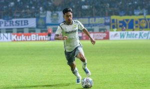 Daisuke Sato saat mengenakan jersey Persib Bandung tengah menggiring bola dengan lincah di lapangan hijau dalam pertandingan resmi.