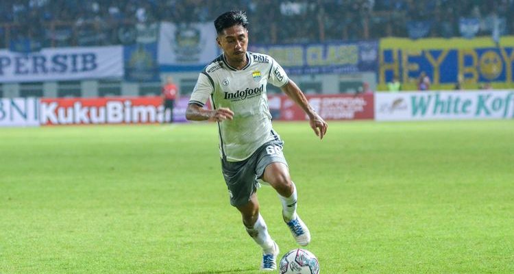 daisuke-sato-persib-gugatan-cas.webp Daisuke Sato saat mengenakan jersey Persib Bandung tengah menggiring bola dengan lincah di lapangan hijau dalam pertandingan resmi.
