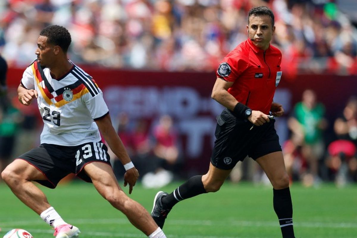 Pemain Timnas Jerman saat bertanding melawan Curacao pada laga perdana Piala Dunia 2026, diawasi oleh wasit berbaju merah.