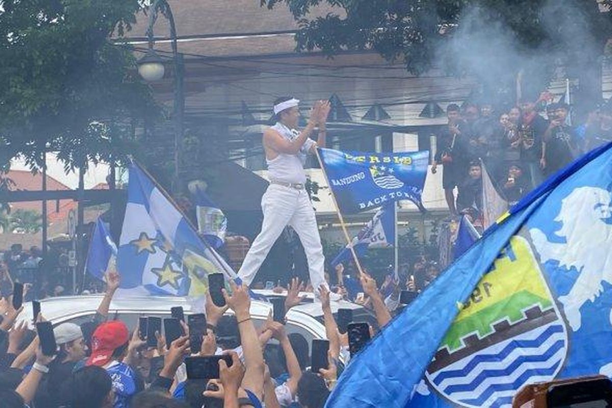 Dedi Mulyadi berdiri di atas mobil menyapa para pendukung Persib Bandung saat merayakan hattrick juara.