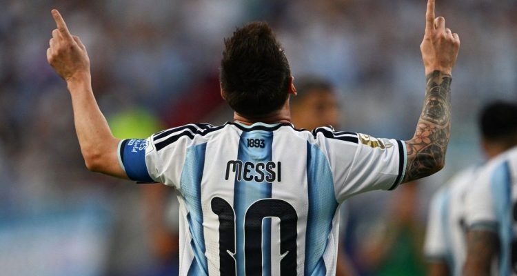 rekor-gol-piala-dunia-lionel-messi.webp Tampak belakang Lionel Messi mengenakan jersey timnas Argentina nomor punggung 10 sambil mengangkat kedua jari telunjuknya ke langit dalam selebrasi ikonisnya.