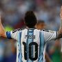 Tampak belakang Lionel Messi mengenakan jersey timnas Argentina nomor punggung 10 sambil mengangkat kedua jari telunjuknya ke langit dalam selebrasi ikonisnya.