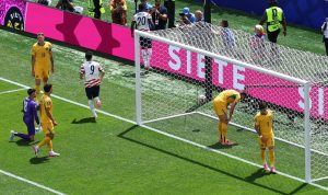Pemain timnas Amerika Serikat nomor punggung 9 merayakan gol ke gawang Australia yang dijaga kiper berbaju ungu dalam pertandingan Piala Dunia.