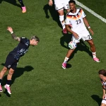 Pemain timnas Jerman menghadang pergerakan pemain Paraguay yang melompat menyundul bola dalam laga Piala Dunia.