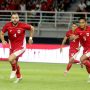 Rizky Ridho mengenakan ban kapten kuning di lengan kirinya saat berlari di lapangan bersama Jordi Amat dalam pertandingan Timnas Indonesia.