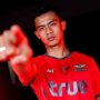 Pemain sepak bola Timnas Indonesia, Pratama Arhan, berpose menunjuk ke arah kamera sambil mengenakan jersey merah resmi Bangkok United FC.