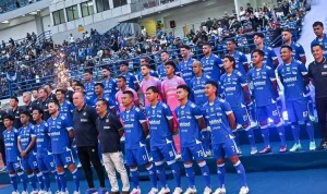 Skuat lengkap Persib Bandung berfoto bersama mengenakan jersey biru di tepi lapangan sebelum pertandingan dimulai.