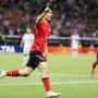 Gelandang Korea Selatan Hwang In-beom berlari merayakan gol dengan menunjuk ke atas di lapangan sepak bola.