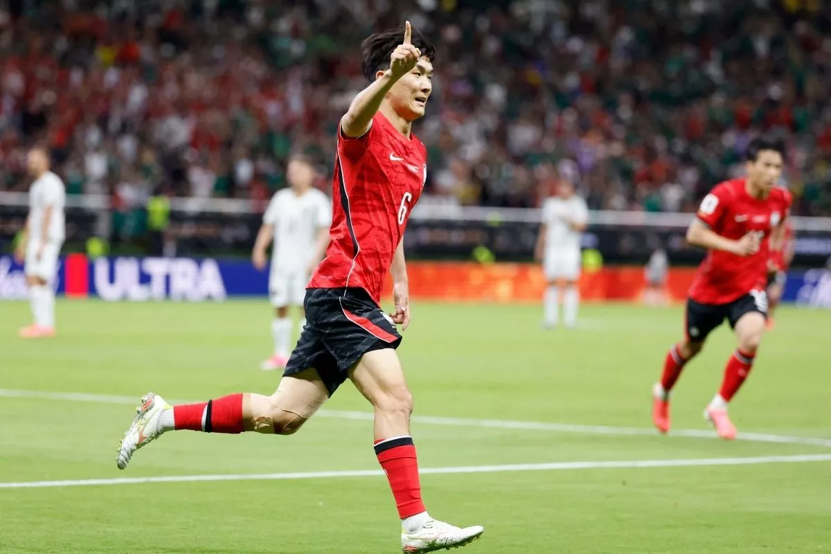 Gelandang Korea Selatan Hwang In-beom berlari merayakan gol dengan menunjuk ke atas di lapangan sepak bola.