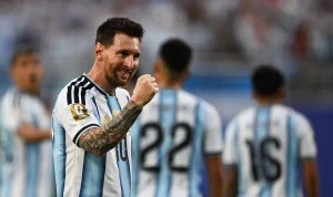 Megabintang Argentina Lionel Messi tersenyum sambil mengepalkan tangan merayakan pencapaian sejarah di atas lapangan.