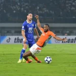Aksi bertahan Gabriel Mutombo saat masih berseragam Ratchaburi FC ketika menghadapi pemain lawan di lapangan hijau.
