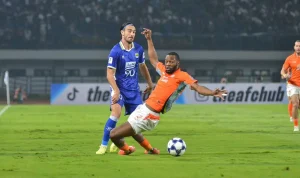 Aksi bertahan Gabriel Mutombo saat masih berseragam Ratchaburi FC ketika menghadapi pemain lawan di lapangan hijau.