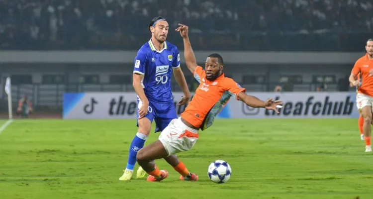 Aksi bertahan Gabriel Mutombo saat masih berseragam Ratchaburi FC ketika menghadapi pemain lawan di lapangan hijau.