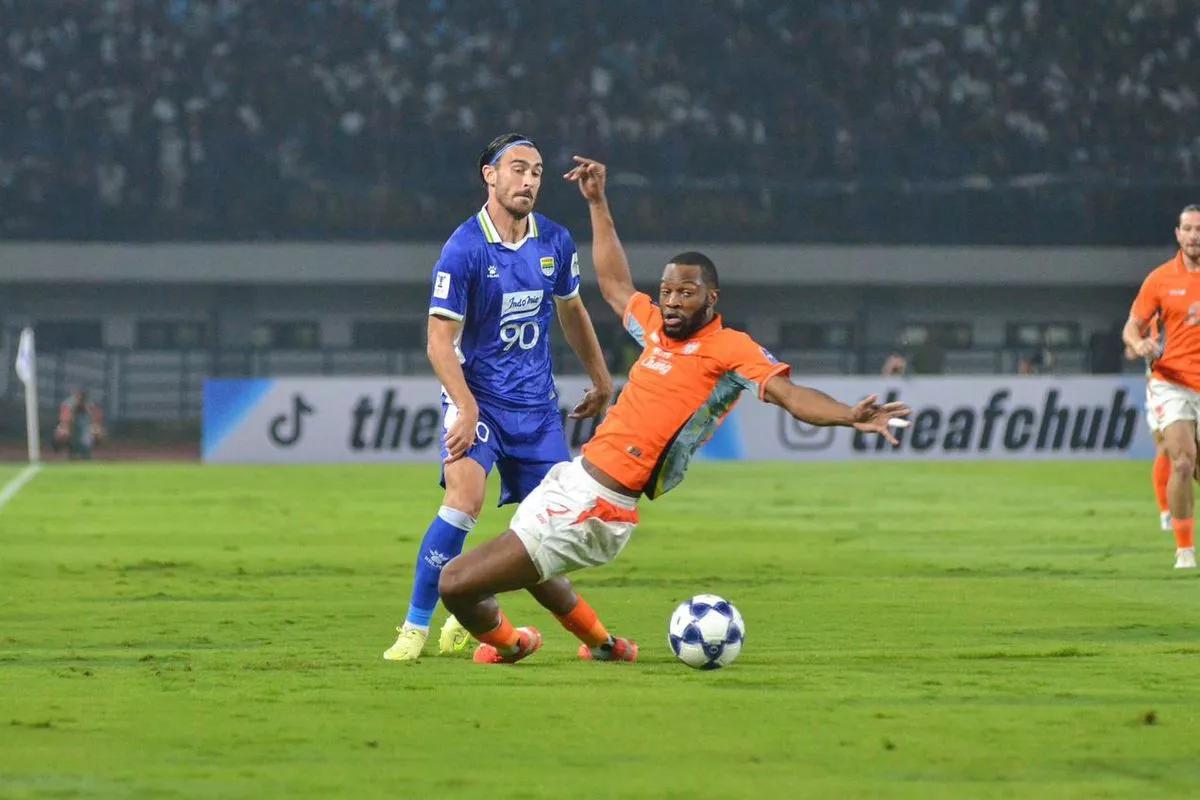 Aksi bertahan Gabriel Mutombo saat masih berseragam Ratchaburi FC ketika menghadapi pemain lawan di lapangan hijau.