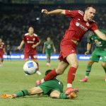 Pemain Persebaya berjersey hijau melakukan sliding tackle menghalau bola dari pemain Persija.