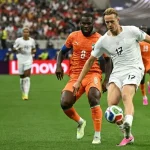 pertandingan-timnas-norwegia-vs-pantai-gading.webp Aksi pemain Timnas Norwegia dengan nomor punggung 17 saat mengontrol bola di bawah kawalan ketat pemain Pantai Gading.