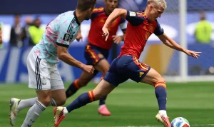 merino-pembeda-timnas-spanyol-lolos-semifinal.webp Gelandang timnas Spanyol, Mikel Merino, sedang menggiring bola dengan cepat melewati kawalan ketat bek Belgia dalam duel sengit babak perempat final.