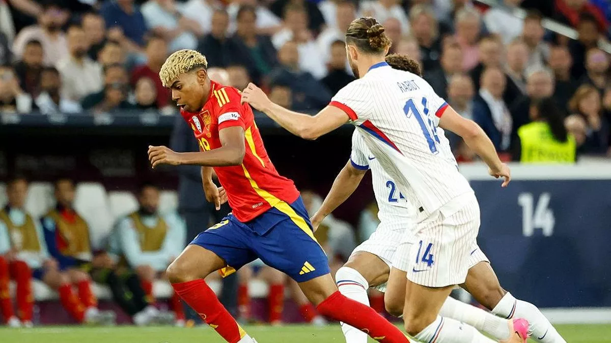 Duel sengit perebutan bola antara penyerang Spanyol, Lamine Yamal, dan gelandang Prancis, Adrien Rabiot. Pertemuan Prancis vs Spanyol di semifinal selalu menyajikan tensi tinggi.