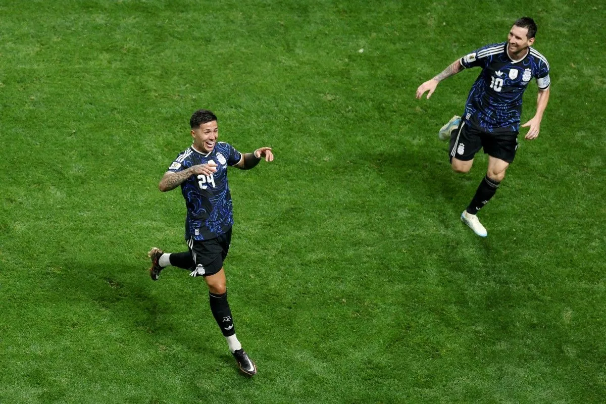 Enzo Fernandez dan Lionel Messi merayakan kemenangan Timnas Argentina di lapangan hijau.
