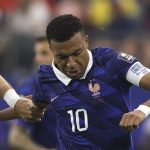 mbappe-top-skor-piala-dunia-2026.webp Kylian Mbappe dengan jersey timnas Prancis nomor 10 sedang berduel berebut bola di lapangan.