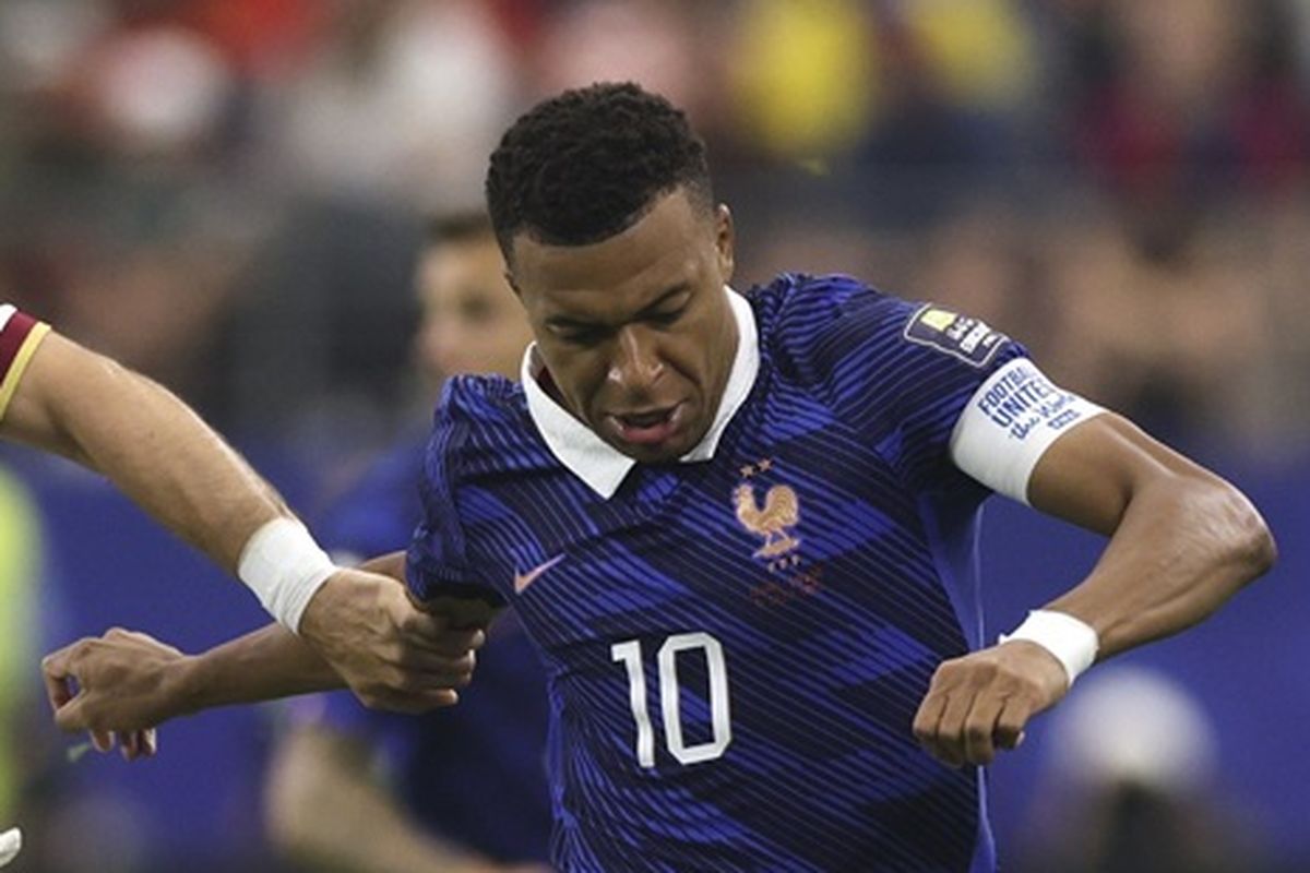 Kylian Mbappe dengan jersey timnas Prancis nomor 10 sedang berduel berebut bola di lapangan.