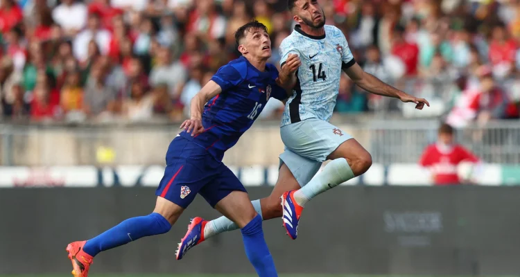 hasil-pertandingan-portugal-vs-kroasia-skor-2-1.webp Pemain Portugal dengan nomor punggung 14 berduel udara memperebutkan bola dengan pemain Kroasia dalam laga sengit yang berakhir 2-1 untuk kemenangan Selecao.