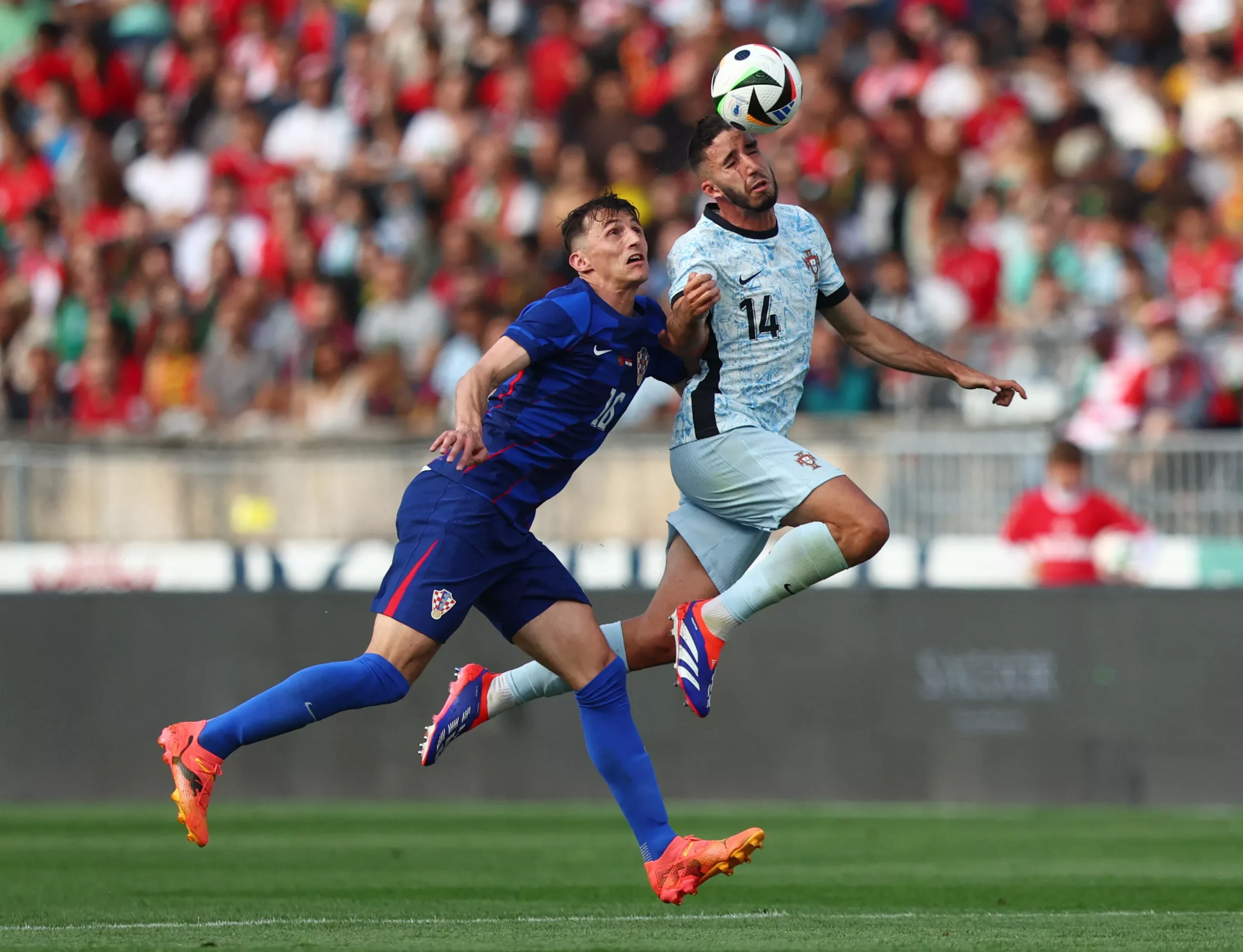 Pemain Portugal dengan nomor punggung 14 berduel udara memperebutkan bola dengan pemain Kroasia dalam laga sengit yang berakhir 2-1 untuk kemenangan Selecao.