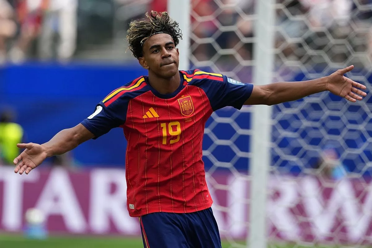 Pemain muda Spanyol Lamine Yamal merayakan gol dengan merentangkan kedua tangannya di depan gawang.