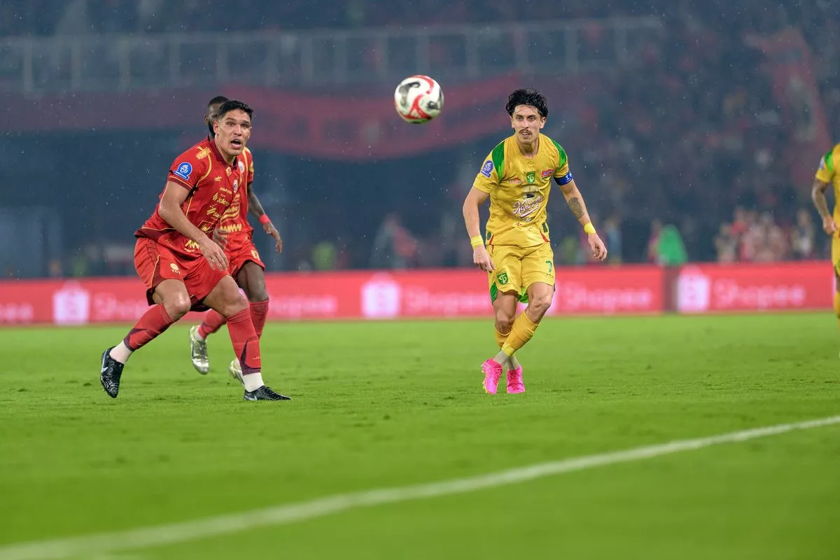 Pertandingan sengit antara pemain Persebaya Surabaya berjersey kuning melawan pemain Persija Jakarta di turnamen Piala Presiden 2026.