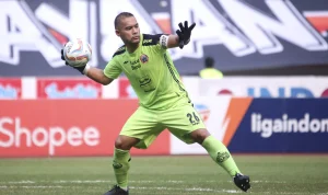 Kiper Persija Jakarta Andritany Ardhiyasa bersiap melempar bola saat bertanding di lapangan.