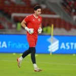 Nadeo Argawinata, penjaga gawang baru Persija Jakarta, terlihat sedang berlari kecil saat sesi latihan di Stadion Utama Gelora Bung Karno dengan jersey latihan berwarna merah.