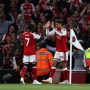 Pemain Arsenal Bukayo Saka dan Kai Havertz melakukan selebrasi high five di sudut lapangan di hadapan para pendukung.