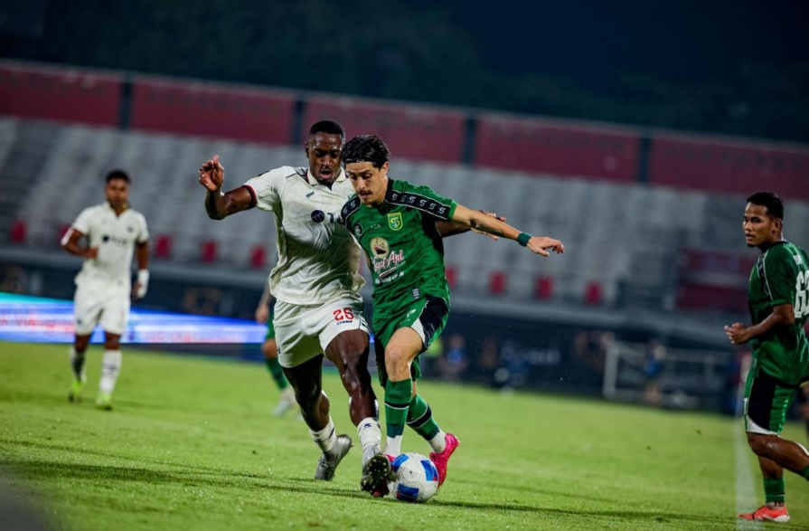 Pemain Persebaya Surabaya berduel perebutan bola dengan pemain Arema FC dalam pertandingan penentu ke babak final.