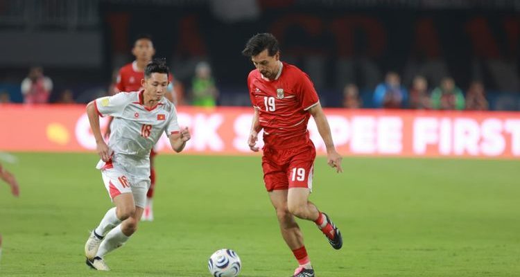 Pemain Timnas Indonesia menggiring bola dalam laga kontra Vietnam yang memengaruhi pergeseran posisi Klasemen Piala AFF.