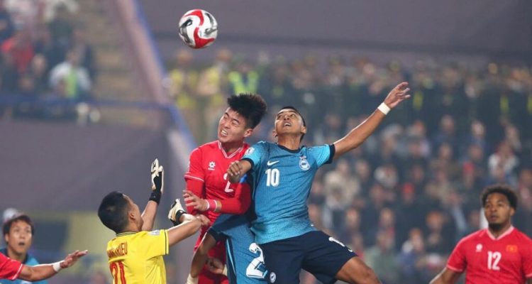 hasil-aff-2026-vietnam-ditahan-singapura-0-0.webp Momen duel udara sengit antara pemain Vietnam dan Singapura pada pertandingan fase grup Piala AFF 2026.