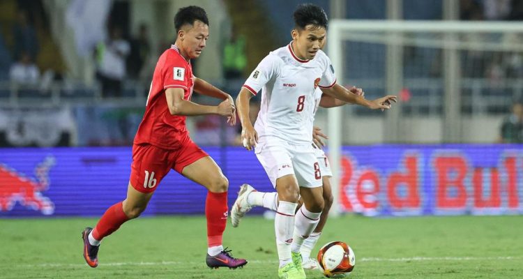 Pemain Timnas Indonesia menguasai bola di bawah bayang-bayang pemain Vietnam.